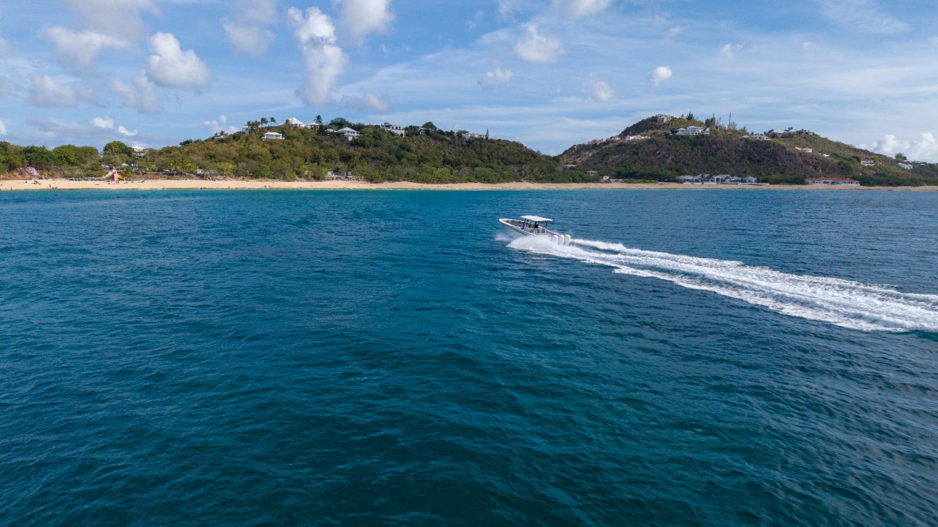 Side profile cruising across a deep blue bay